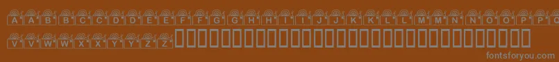 KrSnailMail-fontti – harmaat kirjasimet ruskealla taustalla