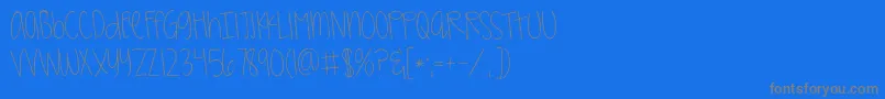 フォントKggirlonfire – 青い背景に灰色の文字