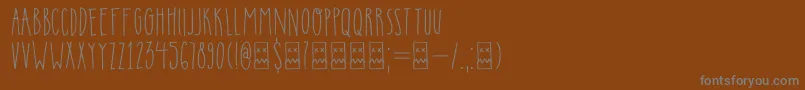 DkInsomniac-fontti – harmaat kirjasimet ruskealla taustalla