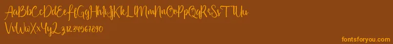 フォントFirdaus – オレンジ色の文字が茶色の背景にあります。