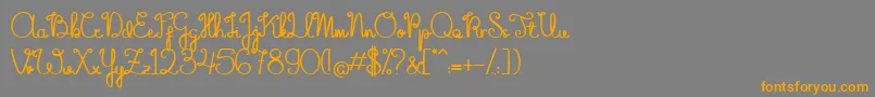 フォントTheFlowerySpring – オレンジの文字は灰色の背景にあります。