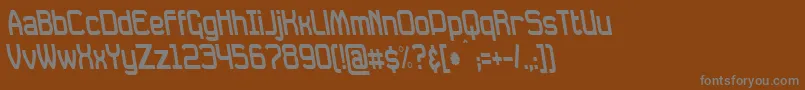 DavilleCondensedRevSlanted-fontti – harmaat kirjasimet ruskealla taustalla
