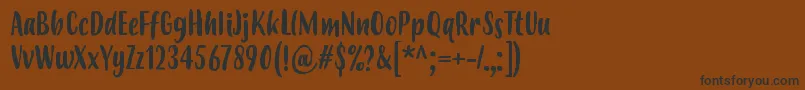 フォントBudidayaRegular – 黒い文字が茶色の背景にあります