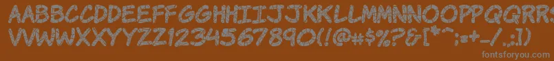 Komikrak-fontti – harmaat kirjasimet ruskealla taustalla