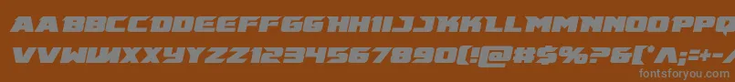 Emissarycondital-fontti – harmaat kirjasimet ruskealla taustalla