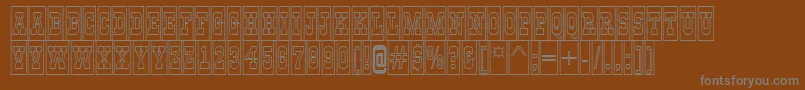 AGildiatitulcmotlBold-fontti – harmaat kirjasimet ruskealla taustalla