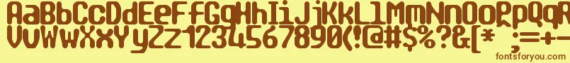 フォントTragicBrk – 茶色の文字が黄色の背景にあります。