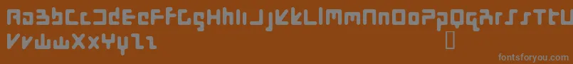 FlotsamStiffUpper-fontti – harmaat kirjasimet ruskealla taustalla