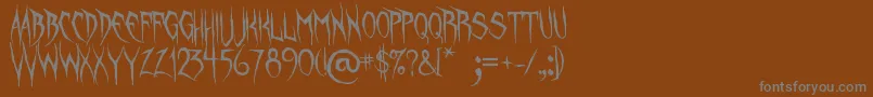 フォントUnquietSpirits – 茶色の背景に灰色の文字