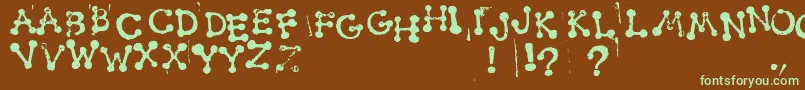 フォントSmudgyDotStamps – 緑色の文字が茶色の背景にあります。