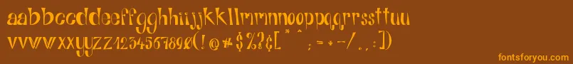 フォントAlphabitsRegular – オレンジ色の文字が茶色の背景にあります。