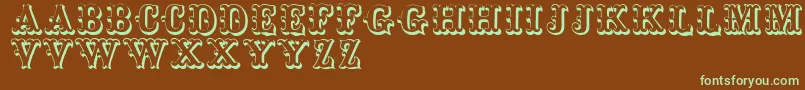 フォントToskanischeegyptienneinitialen – 緑色の文字が茶色の背景にあります。