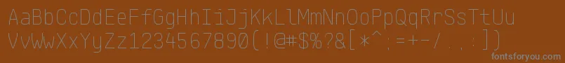 Fonte KlartextMonoThin – fontes cinzas em um fundo marrom
