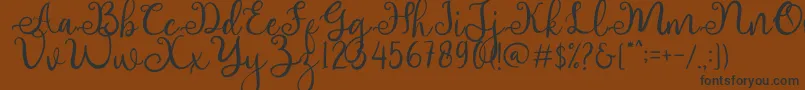 adhellita-Schriftart – Schwarze Schriften auf braunem Hintergrund