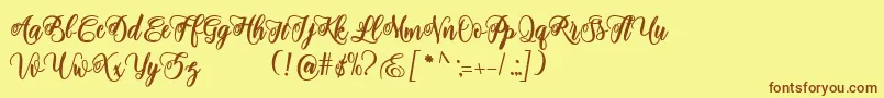 フォントadinda script – 茶色の文字が黄色の背景にあります。
