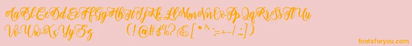 フォントadinda script – オレンジの文字がピンクの背景にあります。