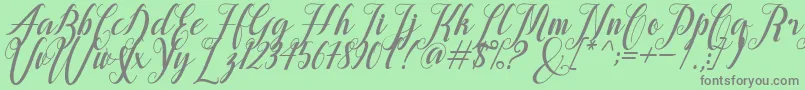 alongtime-fontti – harmaat kirjasimet vihreällä taustalla