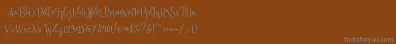 Angelia Script Free Demo Font – Gray Fonts on Brown Background