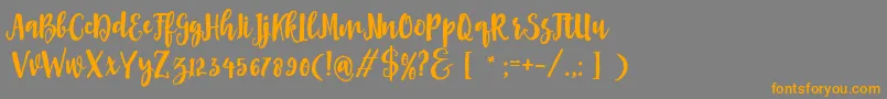 Asly Brush-Schriftart – Orangefarbene Schriften auf grauem Hintergrund