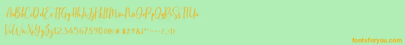 フォントBasstonScript – オレンジの文字が緑の背景にあります。