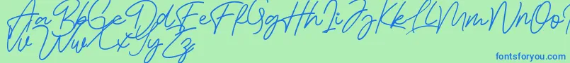 Czcionka Bessita Handwriting Free – niebieskie czcionki na zielonym tle