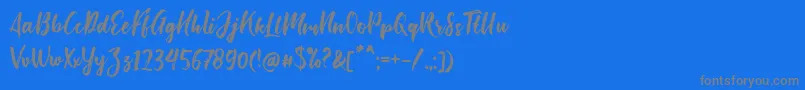 フォントBishella Script – 青い背景に灰色の文字