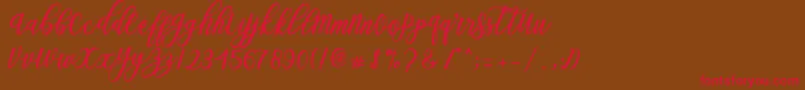 フォントBlessed Script – 赤い文字が茶色の背景にあります。