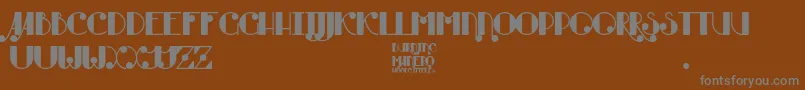Czcionka Burning Manero – szare czcionki na brązowym tle