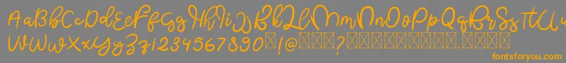 フォントButterflyFree – オレンジの文字は灰色の背景にあります。