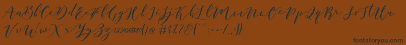 フォントCatandra Brush Script – 黒い文字が茶色の背景にあります