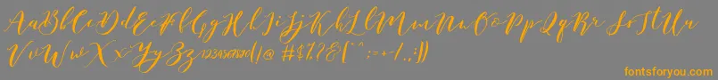 Catandra Brush Script-Schriftart – Orangefarbene Schriften auf grauem Hintergrund