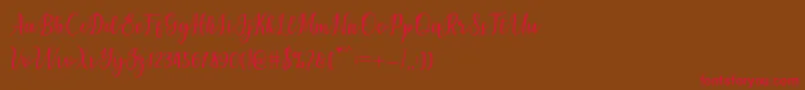 フォントchetlie – 赤い文字が茶色の背景にあります。