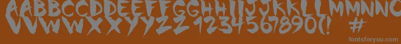 Chinela Brush-fontti – harmaat kirjasimet ruskealla taustalla