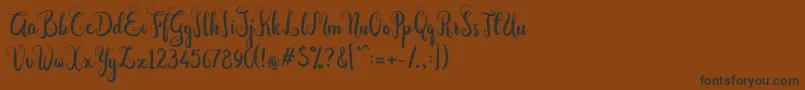 フォントDastan Script – 黒い文字が茶色の背景にあります