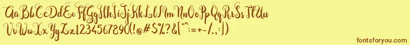 フォントDastan Script – 茶色の文字が黄色の背景にあります。