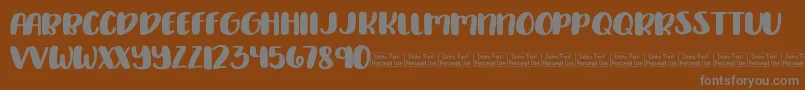 Delirious Demo-fontti – harmaat kirjasimet ruskealla taustalla