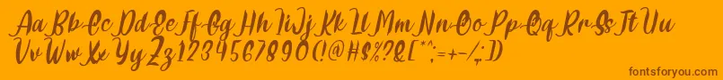 Delumba Italic Font by 7NTypes-fontti – ruskeat fontit oranssilla taustalla