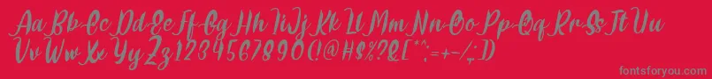 Fonte Delumba Italic Font by 7NTypes – fontes cinzas em um fundo vermelho