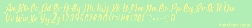 Czcionka Delumba Italic Font by 7NTypes – żółte czcionki na zielonym tle