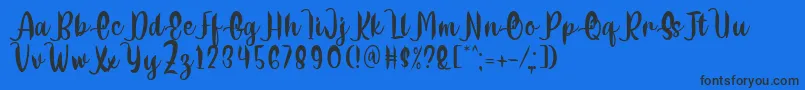 Delumba Regular Font by 7NTypes Font – Black Fonts on Blue Background