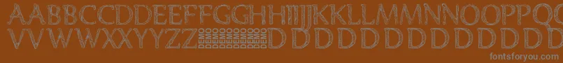 Denka Demo-fontti – harmaat kirjasimet ruskealla taustalla