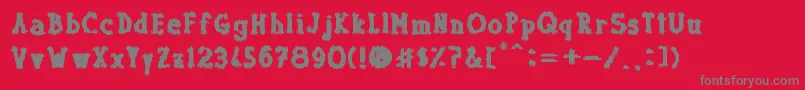 フォントDolor de Muelas – 赤い背景に灰色の文字