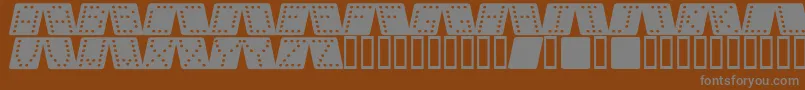Dom sqk -fontti – harmaat kirjasimet ruskealla taustalla