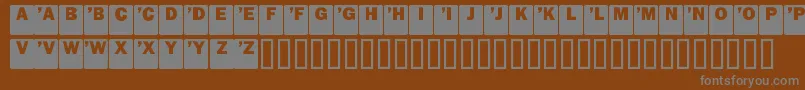 DropCaps Sans-fontti – harmaat kirjasimet ruskealla taustalla
