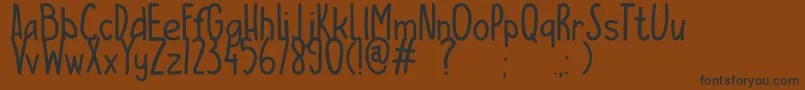 Więcej informacji o czcionce ESCAMPURENAK Czcionka ESCAMPURENAK – czarne czcionki na brązowym tle