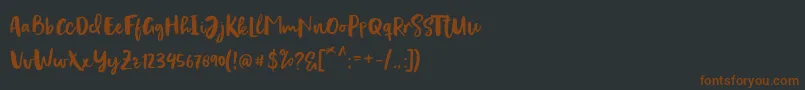 Fonte Evertone Script – fontes marrons em um fundo preto
