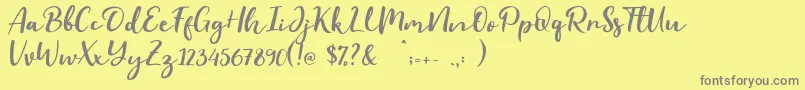 Evident-fontti – harmaat kirjasimet keltaisella taustalla