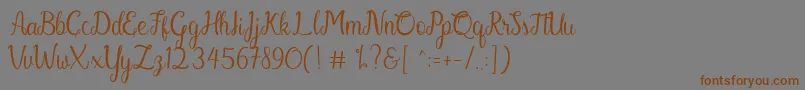 フォントGabriella – 茶色の文字が灰色の背景にあります。