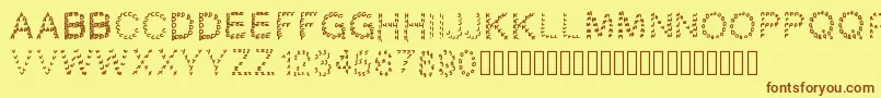 フォントGaellingpates – 茶色の文字が黄色の背景にあります。