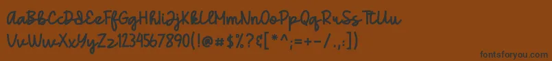 フォントGedang – 黒い文字が茶色の背景にあります